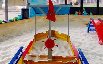A Multicolor Playing Ship in a Sandbox Filled With Sand
