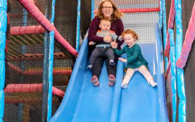 A Mother and Her Son Sliding Down a Blue Slide