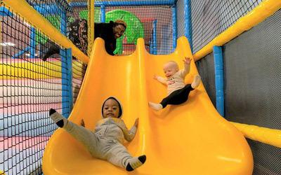 Kids Going Down a Yellow Color Slide in the Park